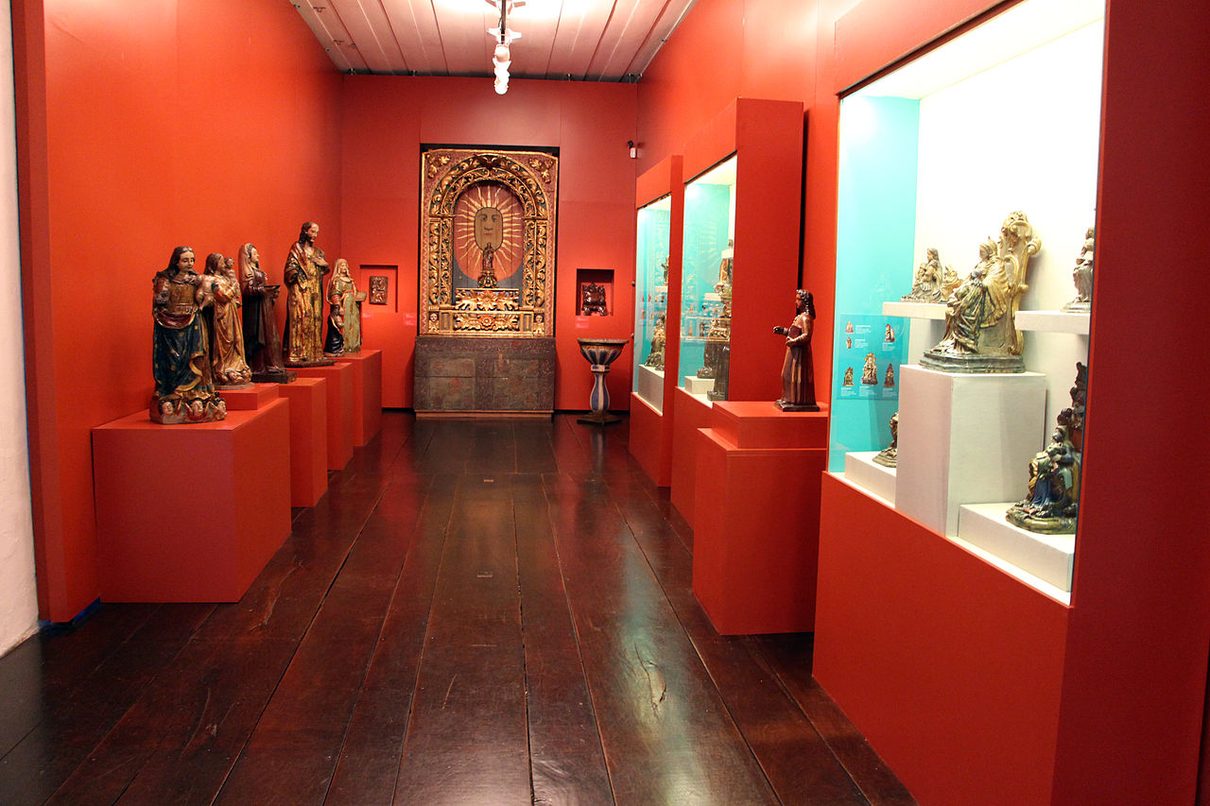 A room at the Museu de Arte Sacra de São Paulo with religious figures displayed in cases and niches. Foto: Saliko/Wikimedia Commons